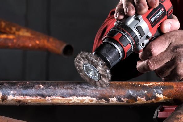 Person entfernt Rost von Metall